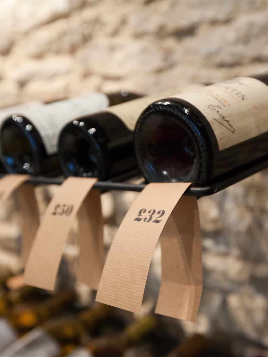 Oeno Wines close-up of back-lit tasting notes and wine bottles on bespoke modular racking, Cirencester